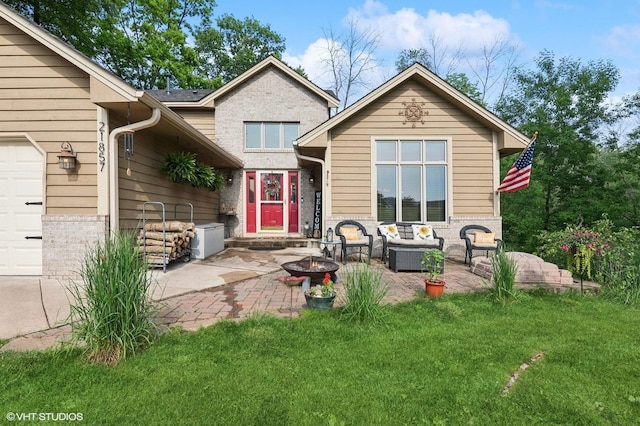 21857 Iden Avenue Pl N, Forest Lake, MN 55025 - back of property with an outdoor living space with a fire pit, a lawn, an attached garage, brick siding, and a patio