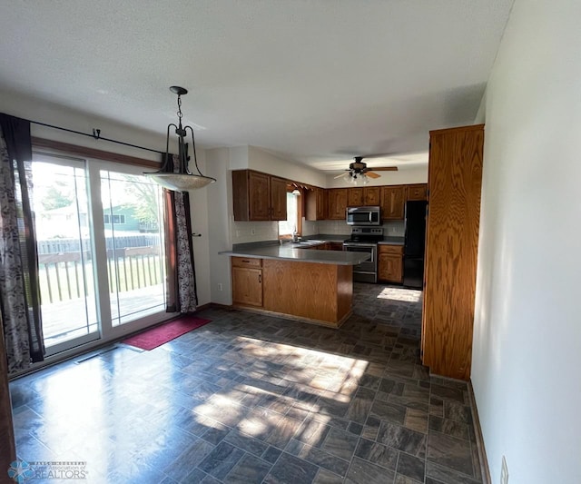 614 8th St E, West Fargo, ND 58078 - kitchen featuring stainless steel appliances, a sink, a peninsula, and baseboards