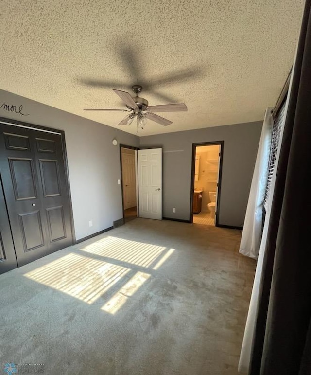 614 8th St E, West Fargo, ND 58078 - unfurnished bedroom featuring light colored carpet, a textured ceiling, ensuite bath, a ceiling fan, and baseboards
