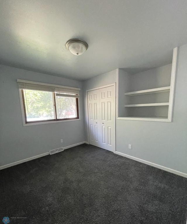 614 8th St E, West Fargo, ND 58078 - unfurnished bedroom featuring dark colored carpet, baseboards, and a closet