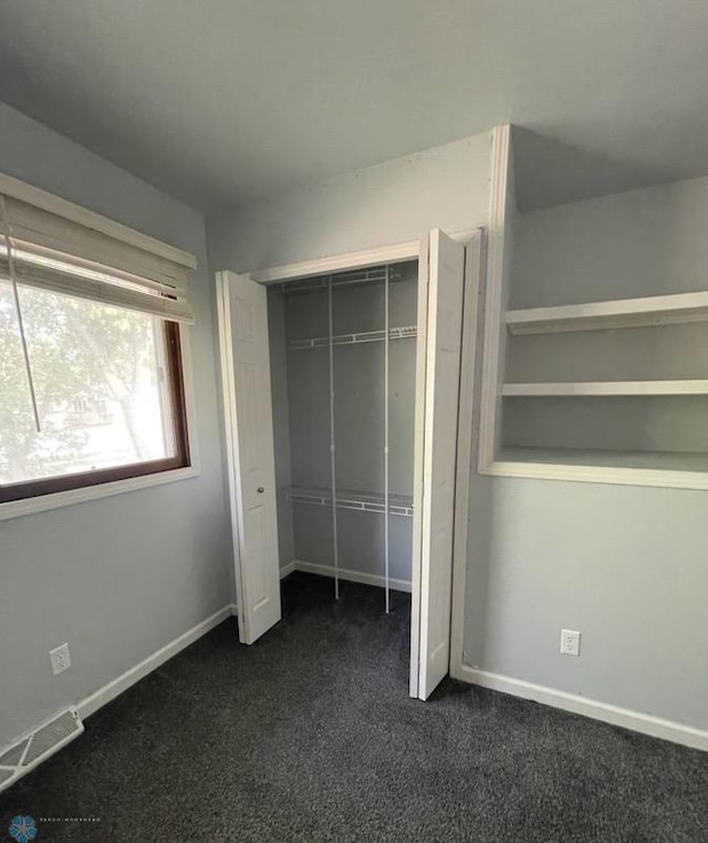614 8th St E, West Fargo, ND 58078 - unfurnished bedroom with dark colored carpet, a closet, and baseboards