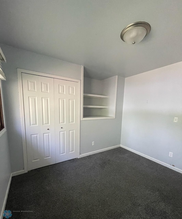 614 8th St E, West Fargo, ND 58078 - unfurnished bedroom featuring dark carpet, baseboards, and a closet