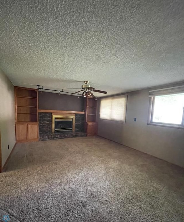 614 8th St E, West Fargo, ND 58078 - unfurnished living room featuring a textured ceiling, ceiling fan, a brick fireplace, and carpet flooring
