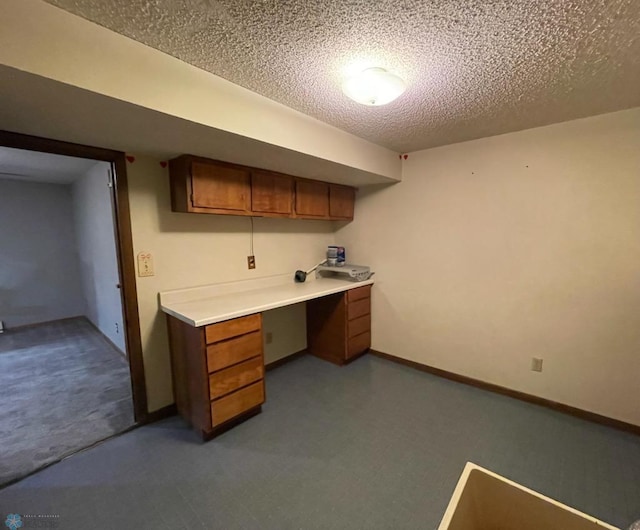 614 8th St E, West Fargo, ND 58078 - unfurnished office with a textured ceiling, carpet flooring, baseboards, and built in desk