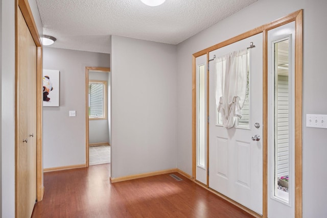 19470 Zumbro Ct NW, Elk River, MN 55330 - entryway with wood finished floors, a textured ceiling, and baseboards