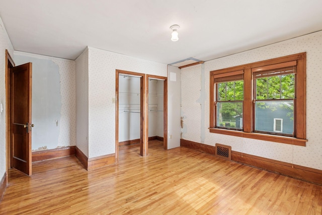 4059 Sheridan Ave N, Minneapolis, MN 55412 - unfurnished bedroom featuring light wood-style flooring, wallpapered walls, and baseboards