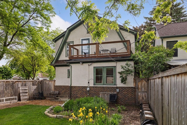 4059 Sheridan Ave N, Minneapolis, MN 55412 - back of property featuring a balcony, stucco siding, brick siding, and a fenced backyard