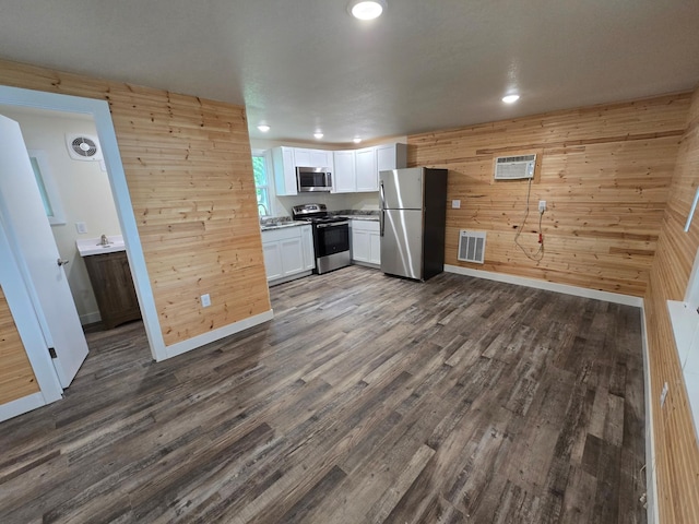 29501 Maplewood Rd Horseshoe, Unit Horseshoe, Callaway, MN 56521 - kitchen with stainless steel appliances, wood walls, dark wood-type flooring, white cabinets, and recessed lighting