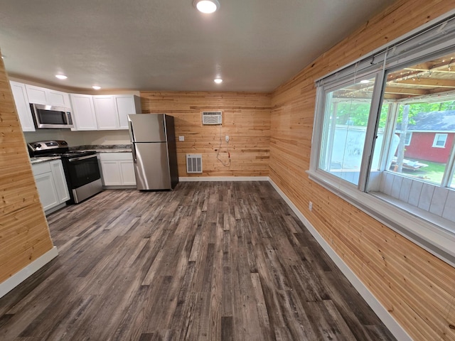 29501 Maplewood Rd Horseshoe, Unit Horseshoe, Callaway, MN 56521 - kitchen with appliances with stainless steel finishes, white cabinets, dark wood-style flooring, wooden walls, and a wall unit AC