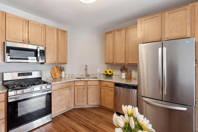 3000 Raleigh Ave Unit 306, Saint Louis Park, MN 55416 - kitchen featuring stainless steel appliances, a sink, light brown cabinets, light wood finished floors, and light stone counters