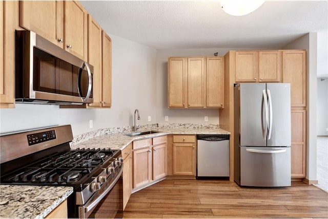 3000 Raleigh Ave Unit 306, Saint Louis Park, MN 55416 - kitchen with stainless steel appliances, a sink, light brown cabinets, and light wood-style flooring