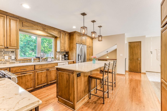 8563 72nd St S, Cottage Grove, MN 55016 - kitchen with stainless steel fridge with ice dispenser, a sink, a kitchen bar, backsplash, and recessed lighting