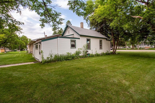 103 3rd St NE, Barnesville, MN 56514 - view of side of home with a yard, a chimney, and roof with shingles