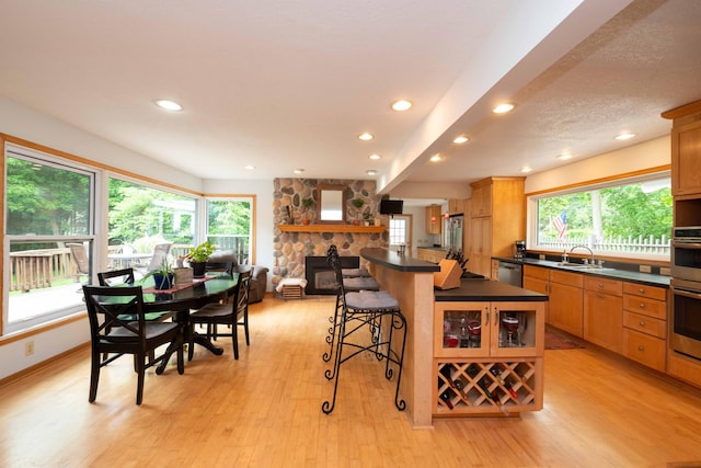 840 Shore Dr W, Orono, MN 55364 - kitchen with dark countertops, a kitchen breakfast bar, stainless steel appliances, light wood-style floors, and recessed lighting