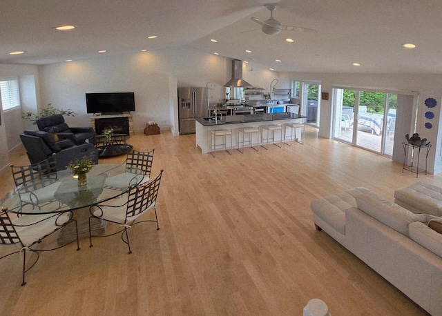 1300 Earle Way, Burnsville, MN 55306 - living room featuring plenty of natural light, light wood-style flooring, a ceiling fan, vaulted ceiling, and recessed lighting