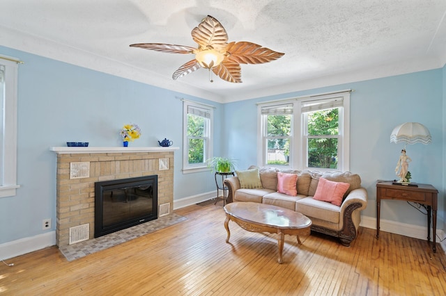 1252 Arkwright St, Saint Paul, MN 55130 - living room with hardwood / wood-style floors, a fireplace, ceiling fan, and a textured ceiling