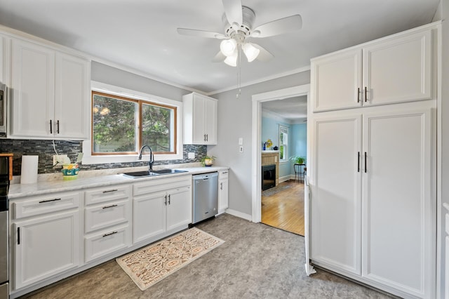 1252 Arkwright St, Saint Paul, MN 55130 - kitchen featuring stainless steel dishwasher, decorative backsplash, ceiling fan, white cabinets, and a fireplace