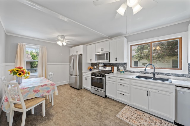 1252 Arkwright St, Saint Paul, MN 55130 - kitchen with stainless steel appliances, a ceiling fan, wainscoting, light countertops, and white cabinets