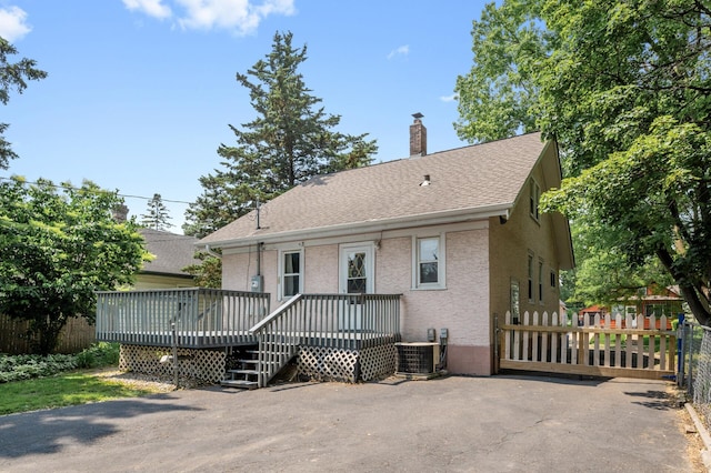 1252 Arkwright St, Saint Paul, MN 55130 - view of front of home with a deck, a chimney, a shingled roof, and stucco siding