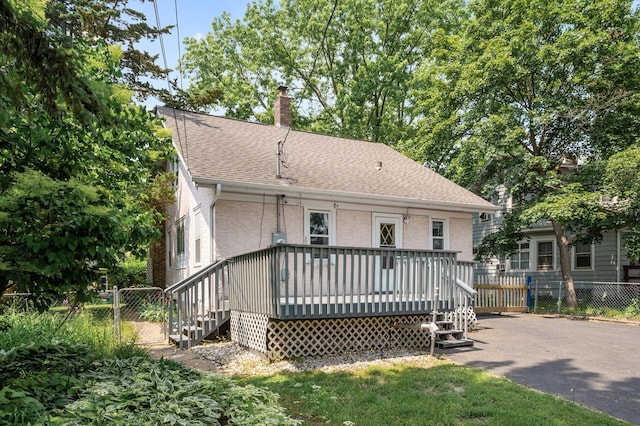 1252 Arkwright St, Saint Paul, MN 55130 - back of property featuring a wooden deck, a shingled roof, and a chimney