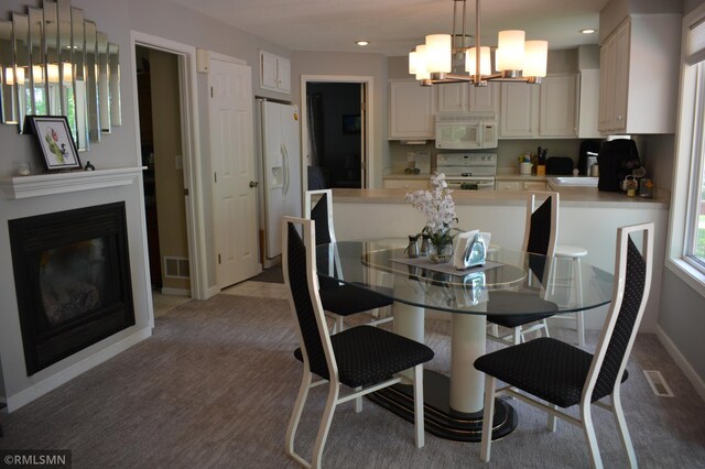 31145 409th Pl, Aitkin, MN 56431 - dining room with a chandelier, recessed lighting, a glass covered fireplace, and light colored carpet