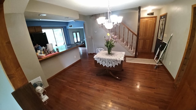 7047 Kingfisher Ln NE, Frohn Twp, MN 56601 - dining space featuring a chandelier, stairs, dark wood-style flooring, and baseboards