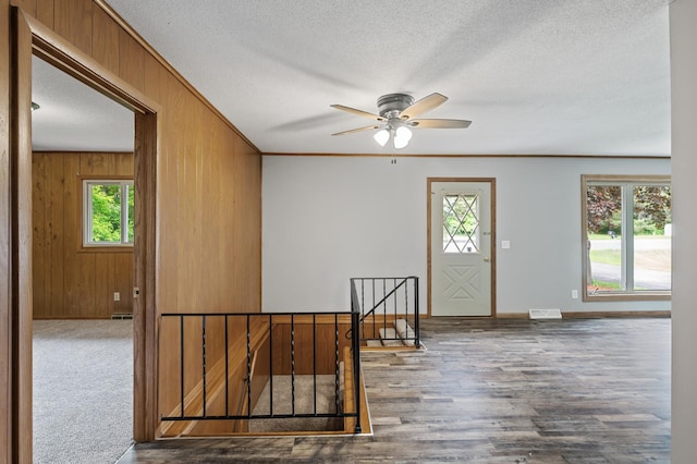 15429 Ramsey Blvd NW, Ramsey, MN 55303 - foyer with healthy amount of natural light, wooden walls, baseboards, ceiling fan, and a textured ceiling