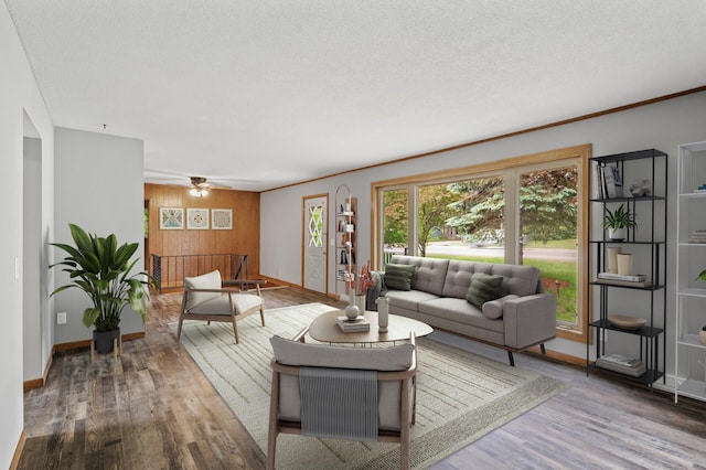 15429 Ramsey Blvd NW, Ramsey, MN 55303 - living room with wood walls, baseboards, wood finished floors, a ceiling fan, and crown molding
