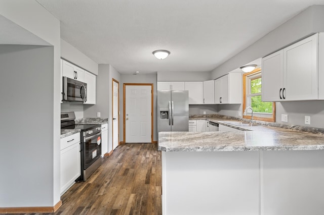 15429 Ramsey Blvd NW, Ramsey, MN 55303 - kitchen featuring appliances with stainless steel finishes, a sink, a peninsula, dark wood-type flooring, and light stone countertops