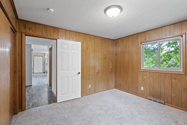 15429 Ramsey Blvd NW, Ramsey, MN 55303 - carpeted empty room with a textured ceiling, a smoke detector, wooden walls, and baseboards