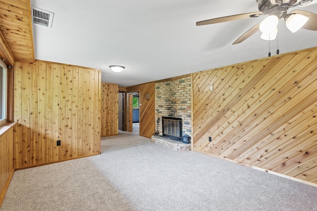 15429 Ramsey Blvd NW, Ramsey, MN 55303 - unfurnished living room with wooden walls, carpet floors, ceiling fan, and a fireplace