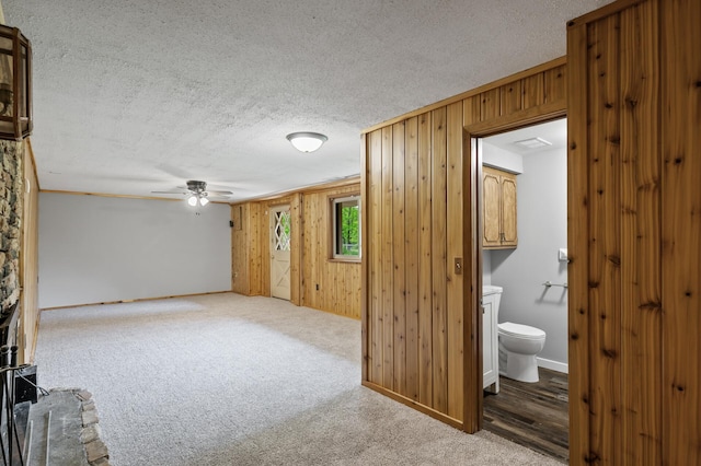 15429 Ramsey Blvd NW, Ramsey, MN 55303 - carpeted spare room with wooden walls, a textured ceiling, a ceiling fan, and baseboards
