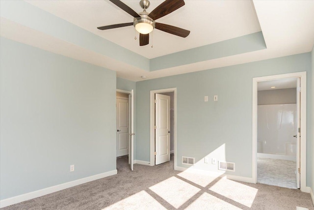 7830 Adler Trl, Inver Grove Heights, MN 55077 - unfurnished bedroom featuring light colored carpet, baseboards, ensuite bathroom, and a tray ceiling