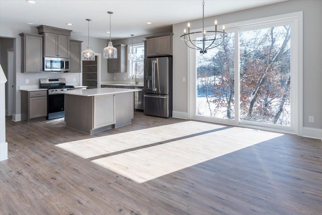 7830 Adler Trl, Inver Grove Heights, MN 55077 - kitchen featuring appliances with stainless steel finishes, wood finished floors, baseboards, a chandelier, and light countertops