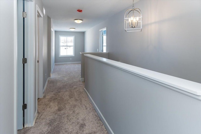 7830 Adler Trl, Inver Grove Heights, MN 55077 - corridor featuring light carpet, a chandelier, baseboards, and an upstairs landing