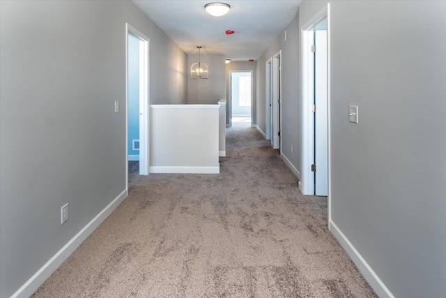 7830 Adler Trl, Inver Grove Heights, MN 55077 - hall with carpet floors, baseboards, a chandelier, and an upstairs landing