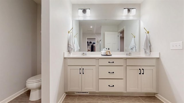 6775 Bluestem Way, Minnetrista, MN 55331 - full bathroom with baseboards, toilet, double vanity, and a closet