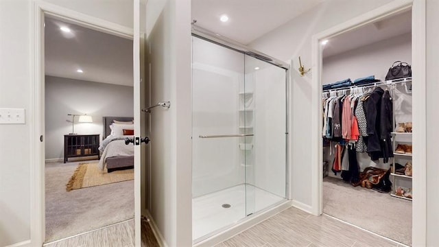 6775 Bluestem Way, Minnetrista, MN 55331 - bathroom featuring a shower stall, connected bathroom, a walk in closet, recessed lighting, and baseboards