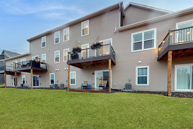 6775 Bluestem Way, Minnetrista, MN 55331 - rear view of house with a balcony, a lawn, and central air condition unit