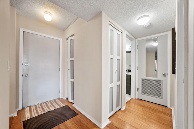 26 10th St W Unit 706, Saint Paul, MN 55102 - foyer with light wood-style floors, a textured ceiling, and baseboards