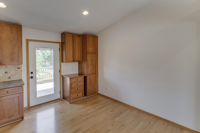 217 Hickory Ln E, Shakopee, MN 55379 - kitchen featuring light wood-style floors, baseboards, recessed lighting, brown cabinetry, and tasteful backsplash