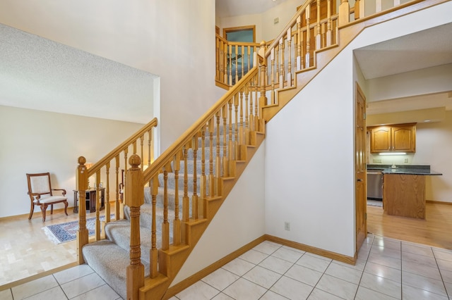 3049 12th St NW, New Brighton, MN 55112 - stairs featuring tile patterned floors, baseboards, and a towering ceiling