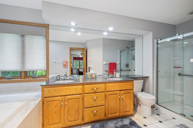 3049 12th St NW, New Brighton, MN 55112 - bathroom featuring a shower stall, double vanity, recessed lighting, a ceiling fan, and toilet