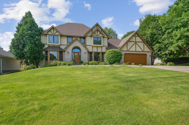 3049 12th St NW, New Brighton, MN 55112 - english style home featuring driveway, a front lawn, an attached garage, and stucco siding