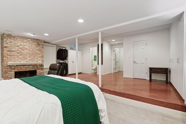 6050 Blake Ridge Rd, Edina, MN 55436 - bedroom featuring wood finished floors, recessed lighting, a fireplace, and connected bathroom