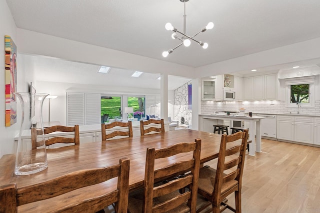 6050 Blake Ridge Rd, Edina, MN 55436 - dining area with light wood finished floors, plenty of natural light, and a chandelier