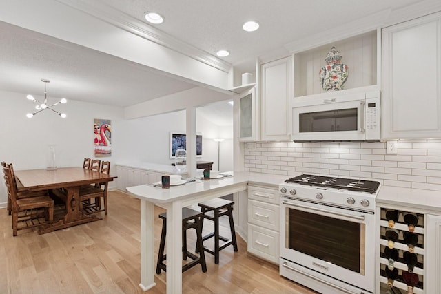 6050 Blake Ridge Rd, Edina, MN 55436 - kitchen featuring white appliances, light countertops, decorative backsplash, a chandelier, and recessed lighting