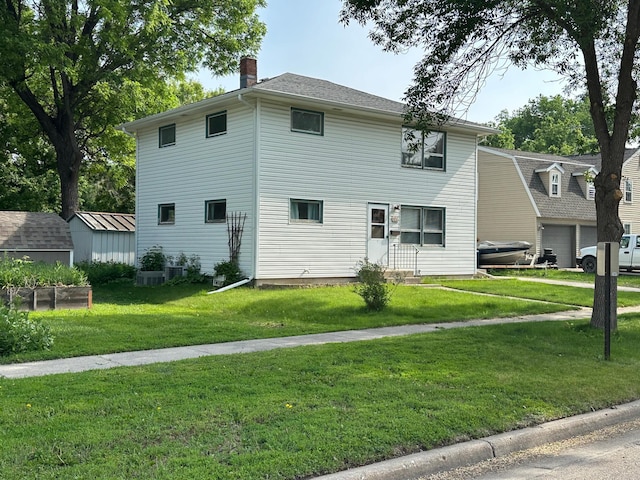 916 5th Ave N, Moorhead, MN 56560 - view of side of home with a lawn, a chimney, and a garage
