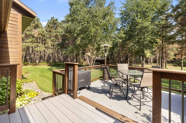 12584 County 18 SW, Brainerd, MN 56401 - wooden terrace featuring outdoor dining area, a yard, and view of wooded area