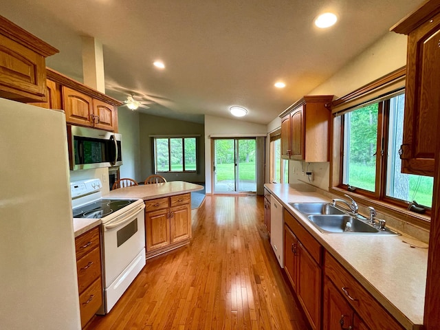 416 Rako St SW, Bemidji, MN 56601 - kitchen with white appliances, a sink, vaulted ceiling, light countertops, and light wood finished floors